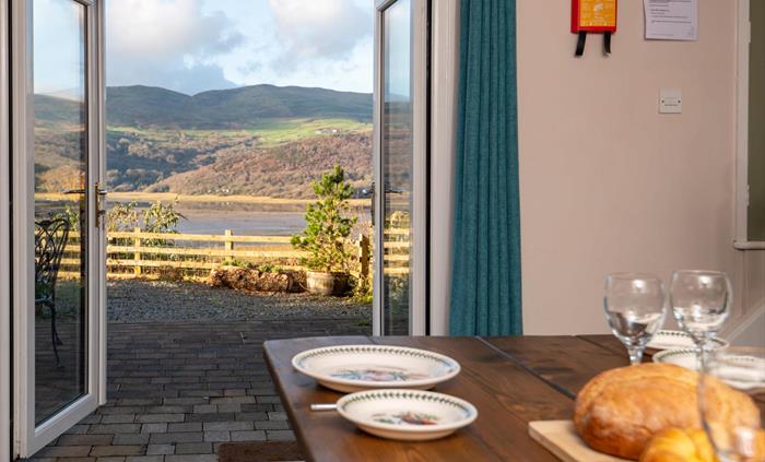 French windows opening from kitchen onto terrace of Mawddach Estuary holiday cottage